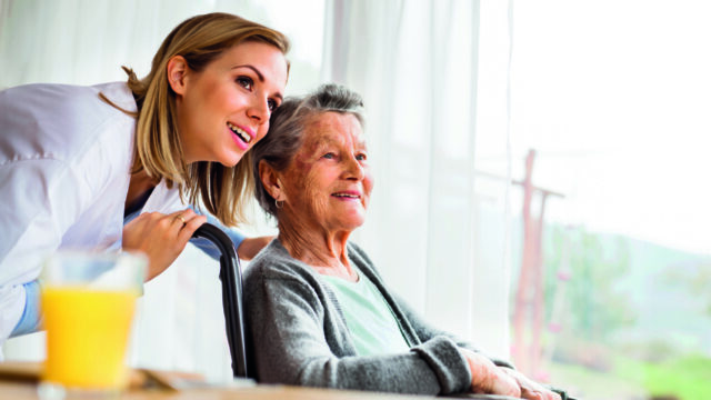 Health visitor and a senior woman during home visit.